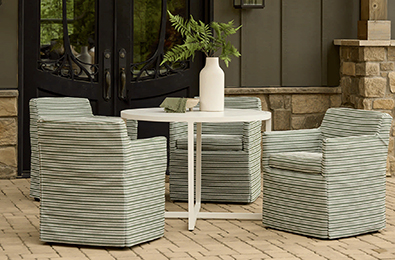 fabric covered chair on a patio by a pot of white flowers