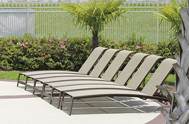 row of tan reclined chaises on a patio