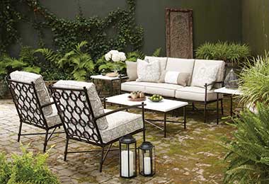 stone patio with moss and ferns around a soft, chairs and coffee table