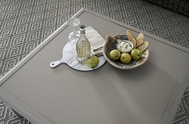 Light brown square table topped with food and drink