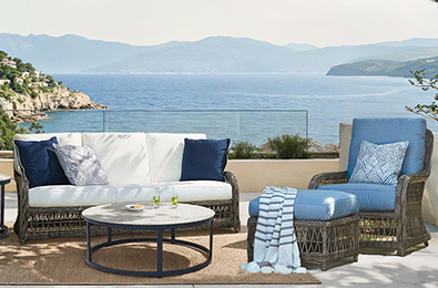 woven brown sofa and chairs with blue and white cushions