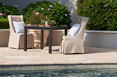 poolside table with white umbrella and tan chairs
