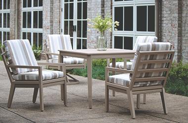 light brown patio table and chairs with striped cushions
