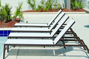 row of tan reclined chaises on a patio