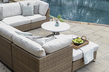 c-shaped woven sectional sofa by a pool